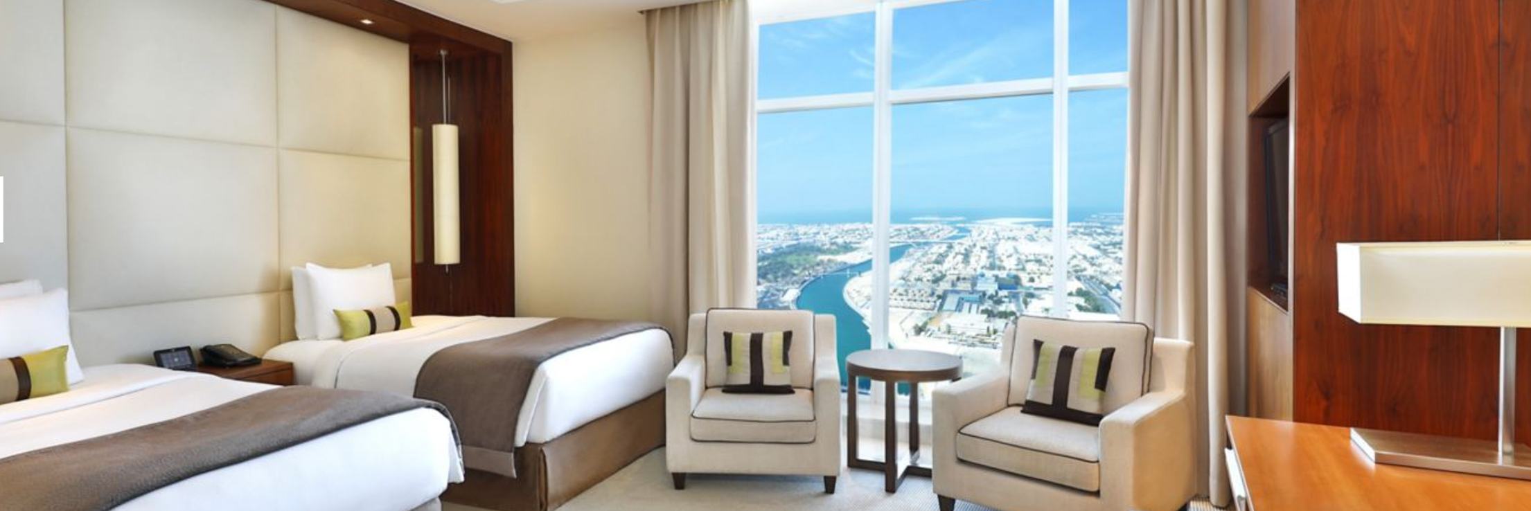 Two beds and seating with large window and natural light